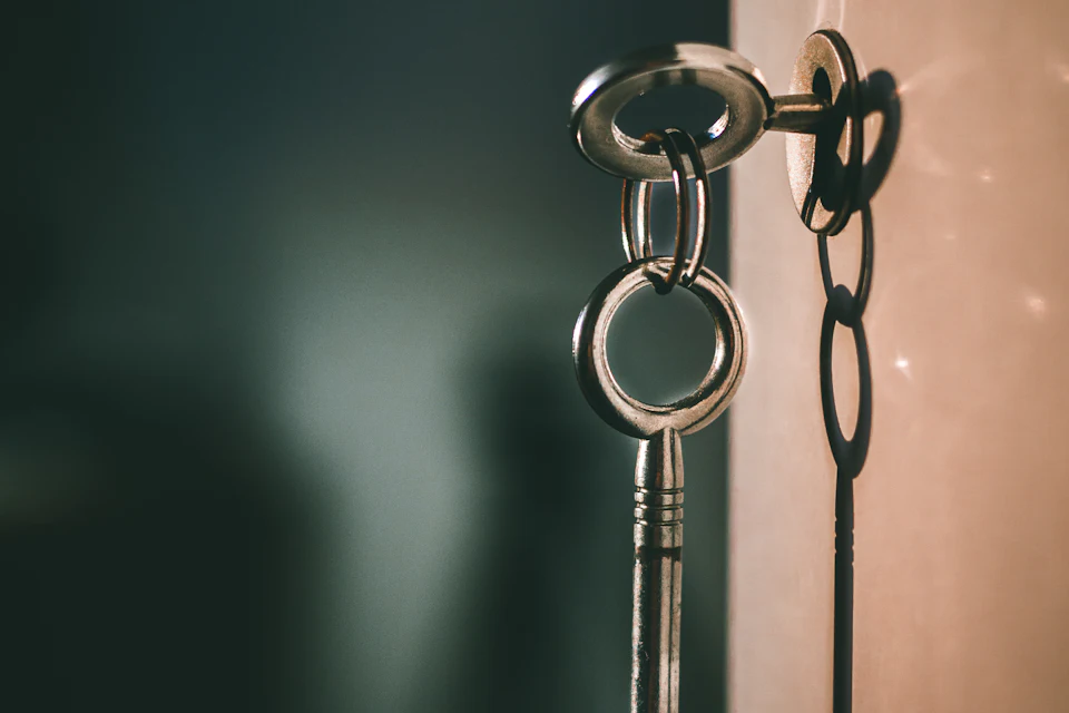Llave metálica en una cerradura, con su sombra en la pared