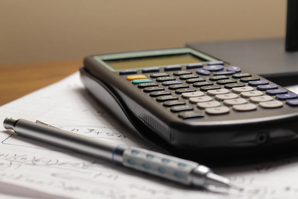 Calculadora y bolígrafo sobre una hoja de papel